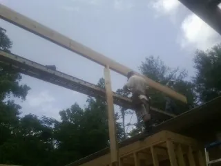 Carpenter setting a ridge beam over a new addition frame — Ice Dam Removal by Roofing Brothers in Beyer