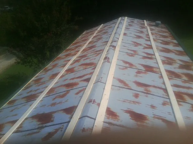 Rusted metal roof panels with new wood purlins before replacement — Storm Damage Roof Repair in Beyer by Roofing Brothers