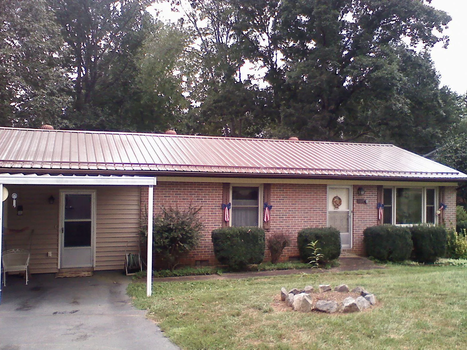 Bronze metal roof and carport on a brick ranch home — Roof Repair work by our crew in Beyer