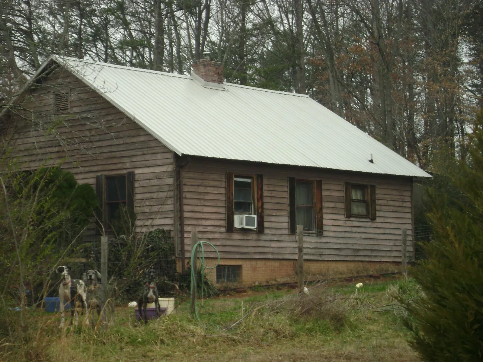 White metal roof on an old wood sided farmhouse, from a Metal Roof Installation job in Beyer